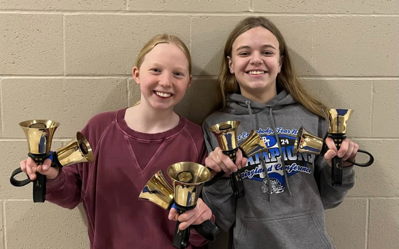 two girls holding handbells