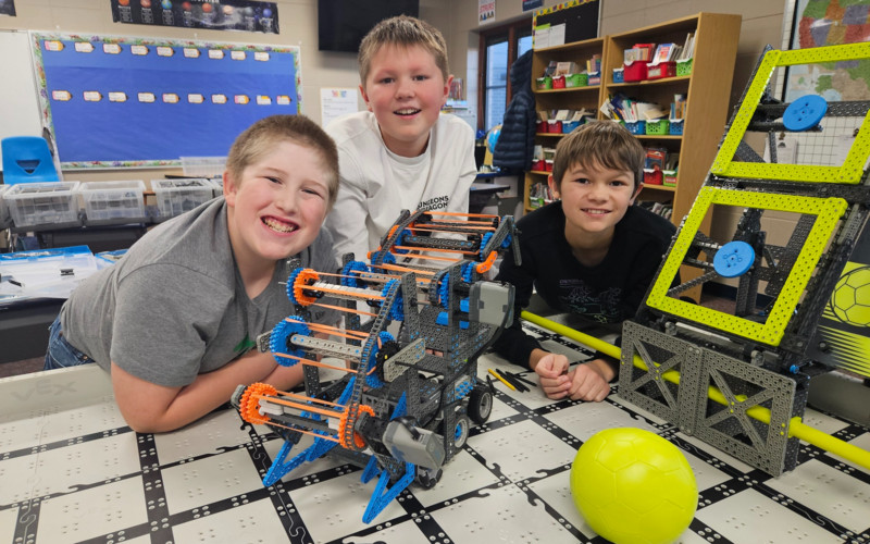 three boys with a robot
